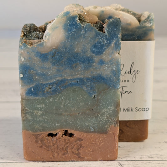 Handcrafted soap bar with natural coloration on a wooden surface