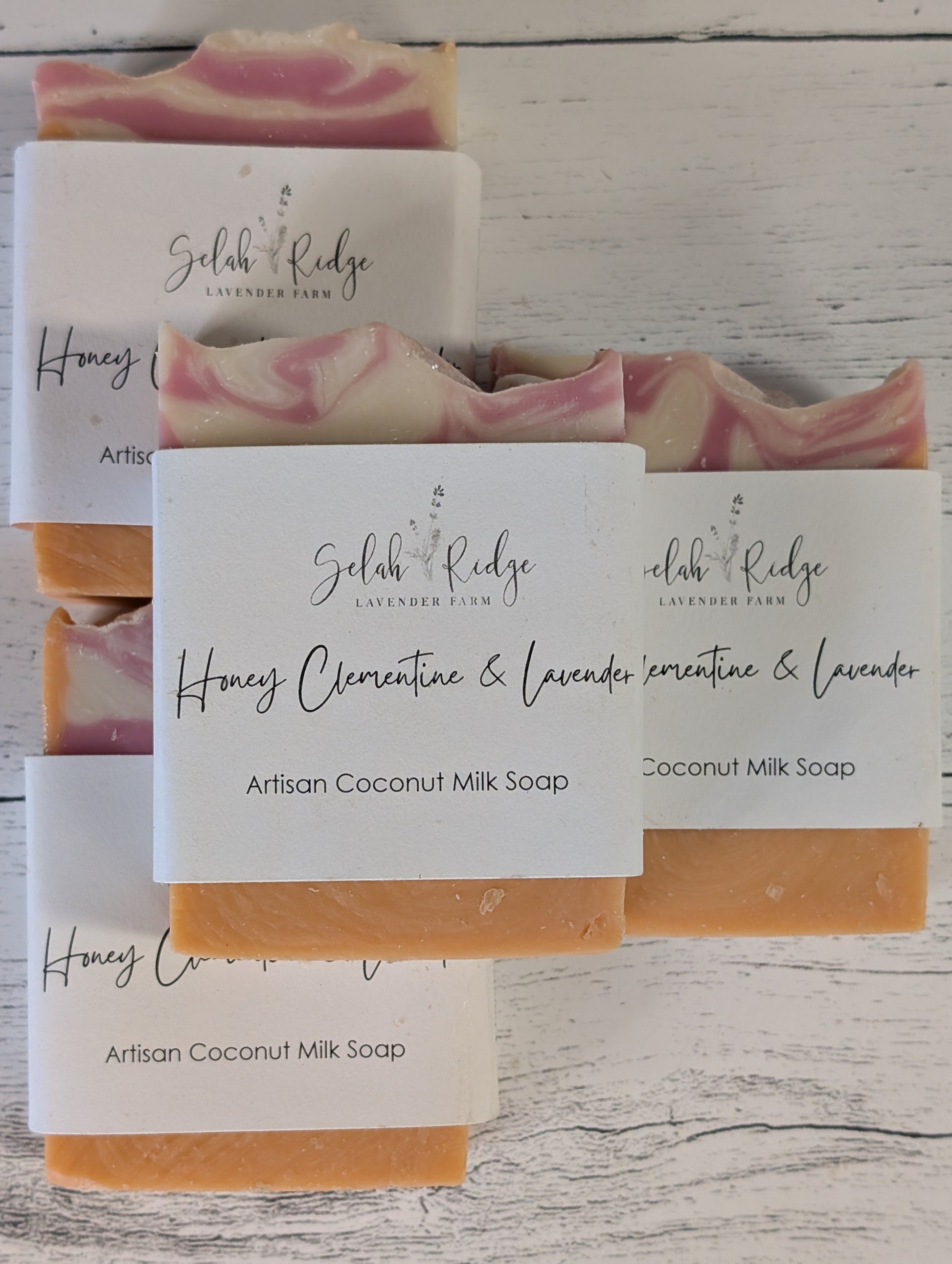 Three bars of soap with visible branding on a wooden surface