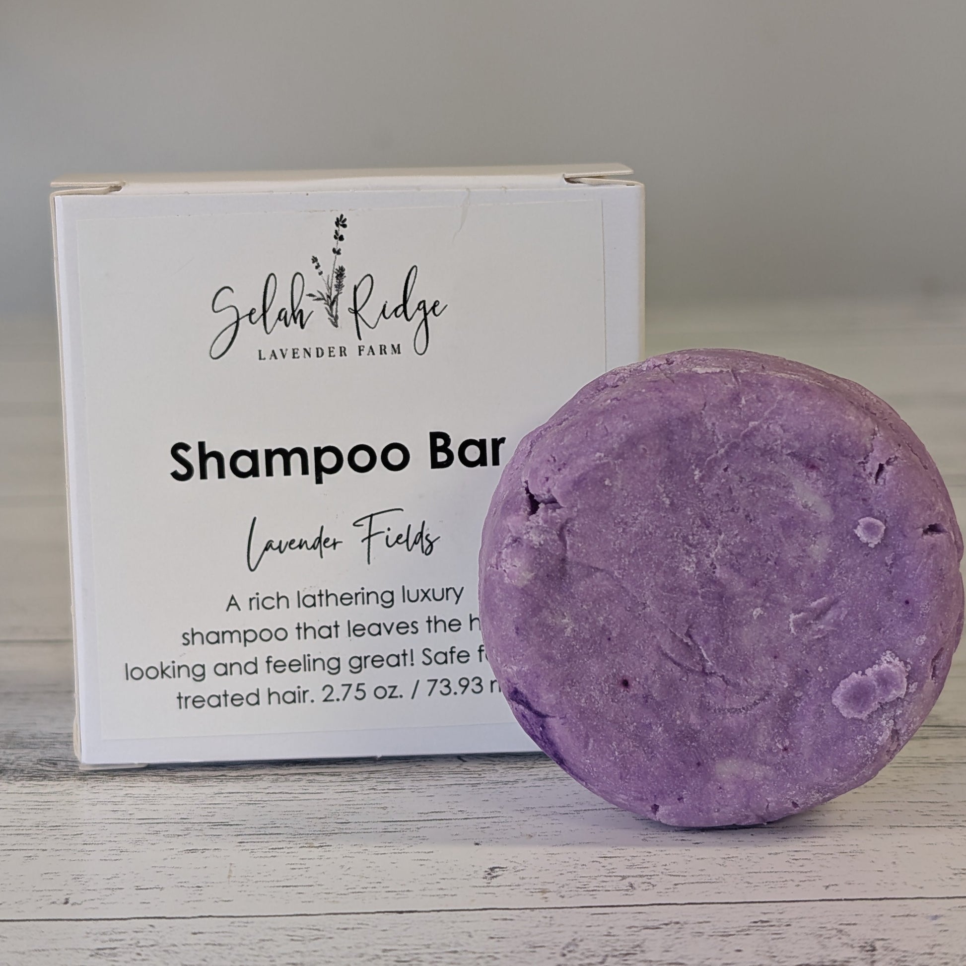 Purple lavender shampoo bar with Selah Ridge packaging on a wooden surface