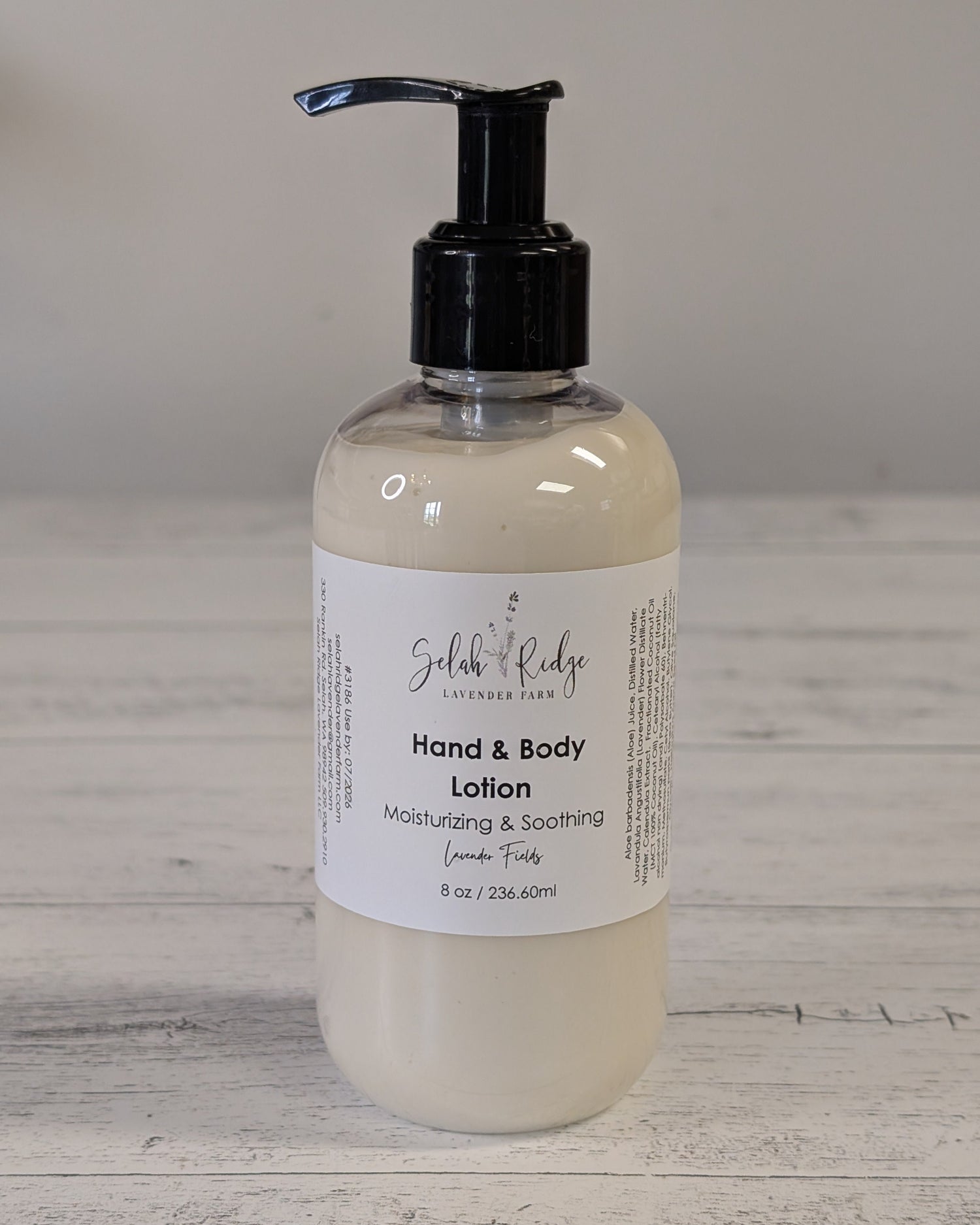 Hand and body lotion bottle with pump on a wooden surface