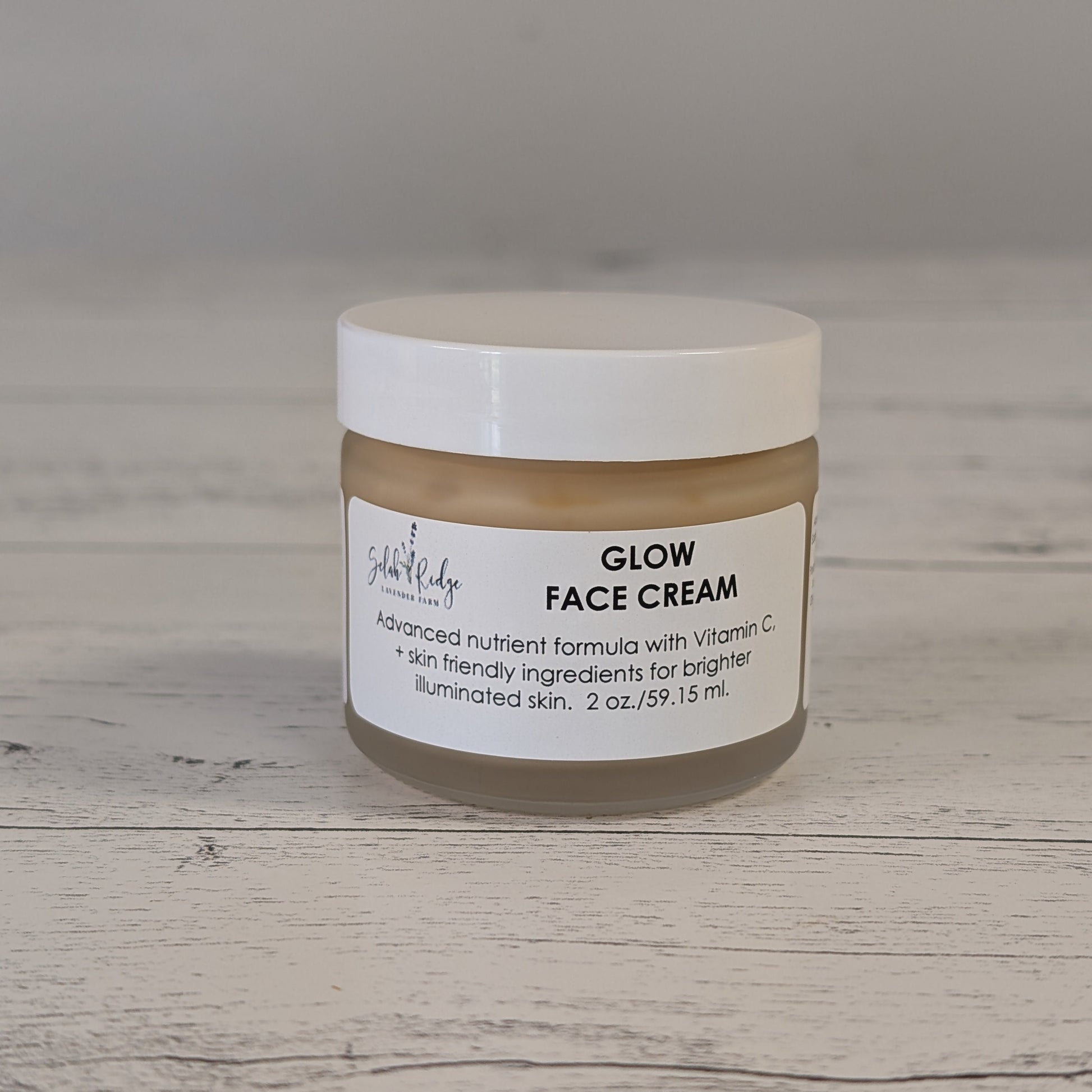 Jar of Glow Face Cream on a wooden surface with a neutral background