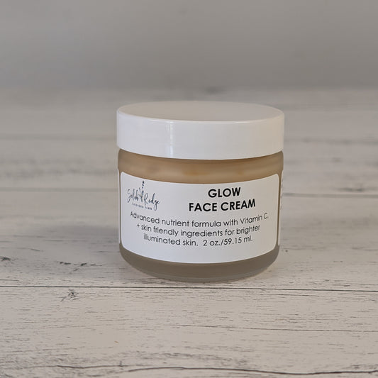 Jar of Glow Face Cream on a wooden surface with a neutral background