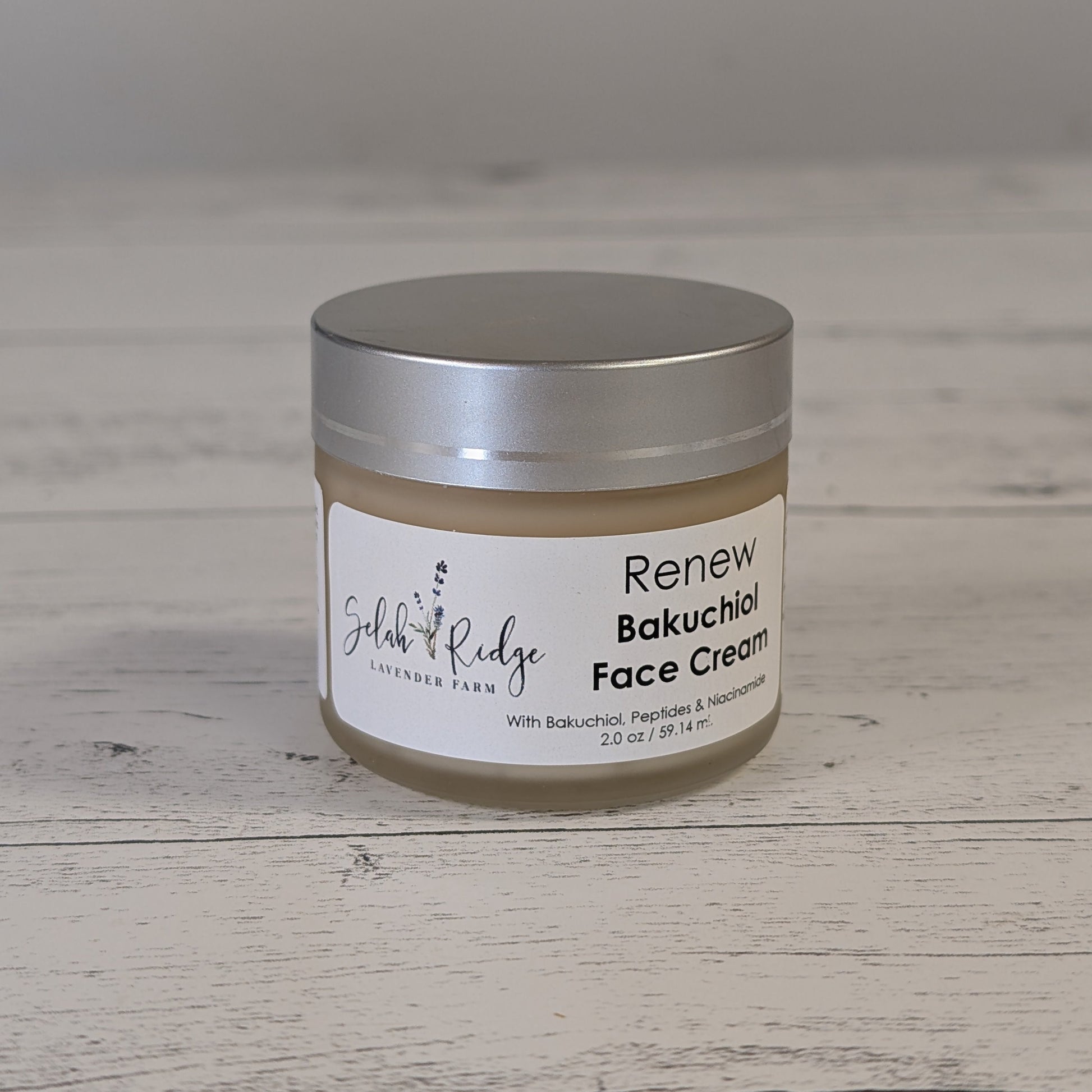 Jar of 'Renew Bakuchiol Face Cream' on a wooden surface with a neutral background