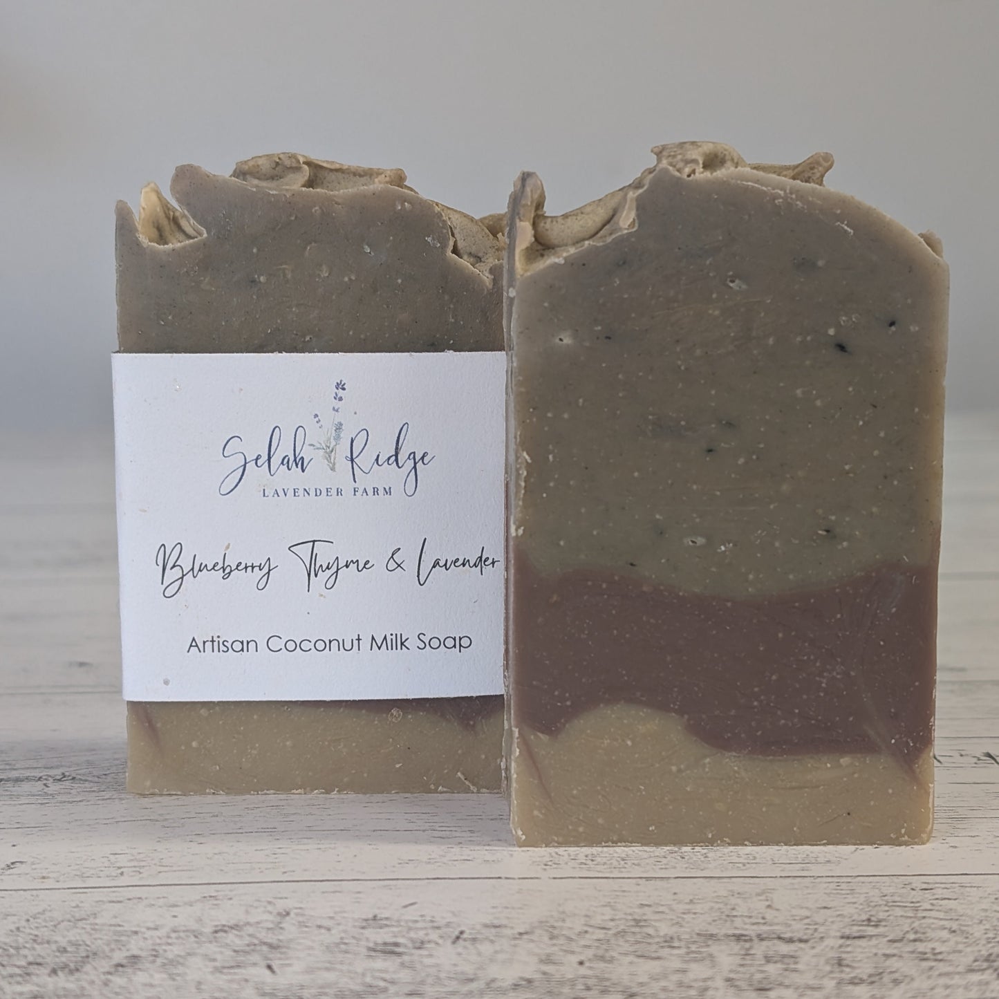 Two layered soap bars with a label on a wooden surface