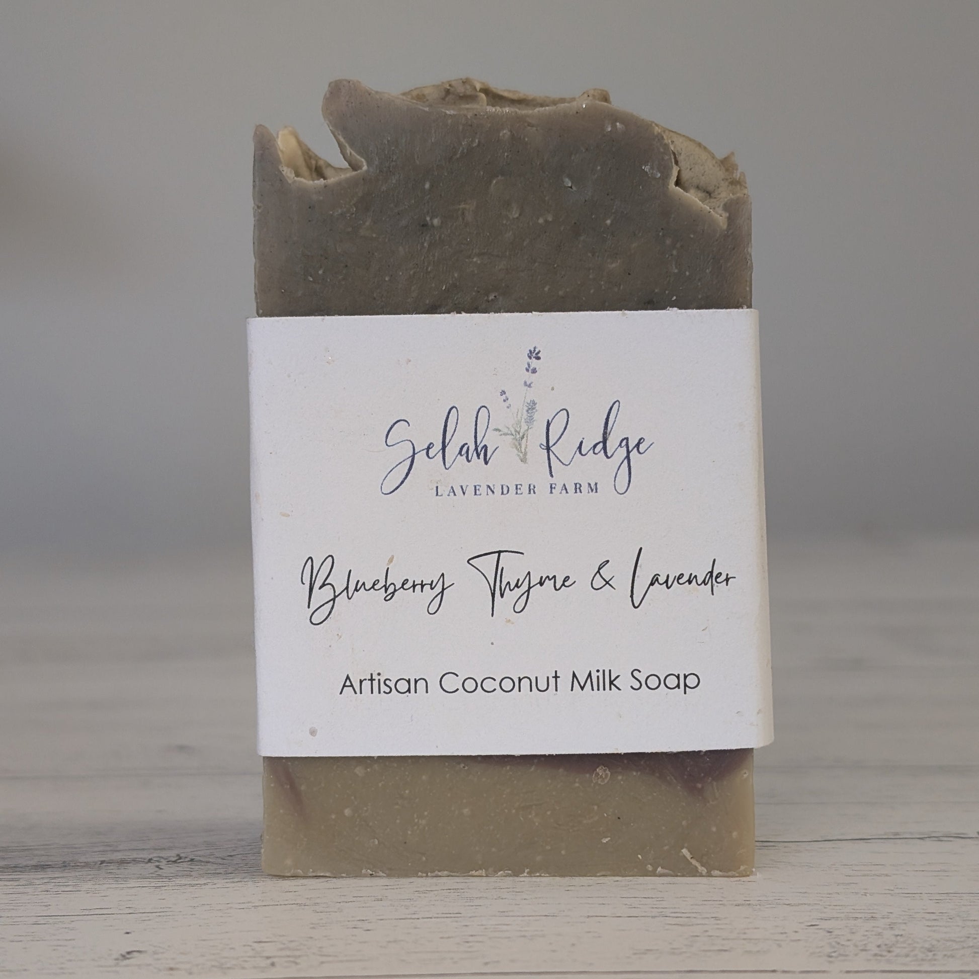 Artisan coconut milk soap bar with a label on a wooden surface