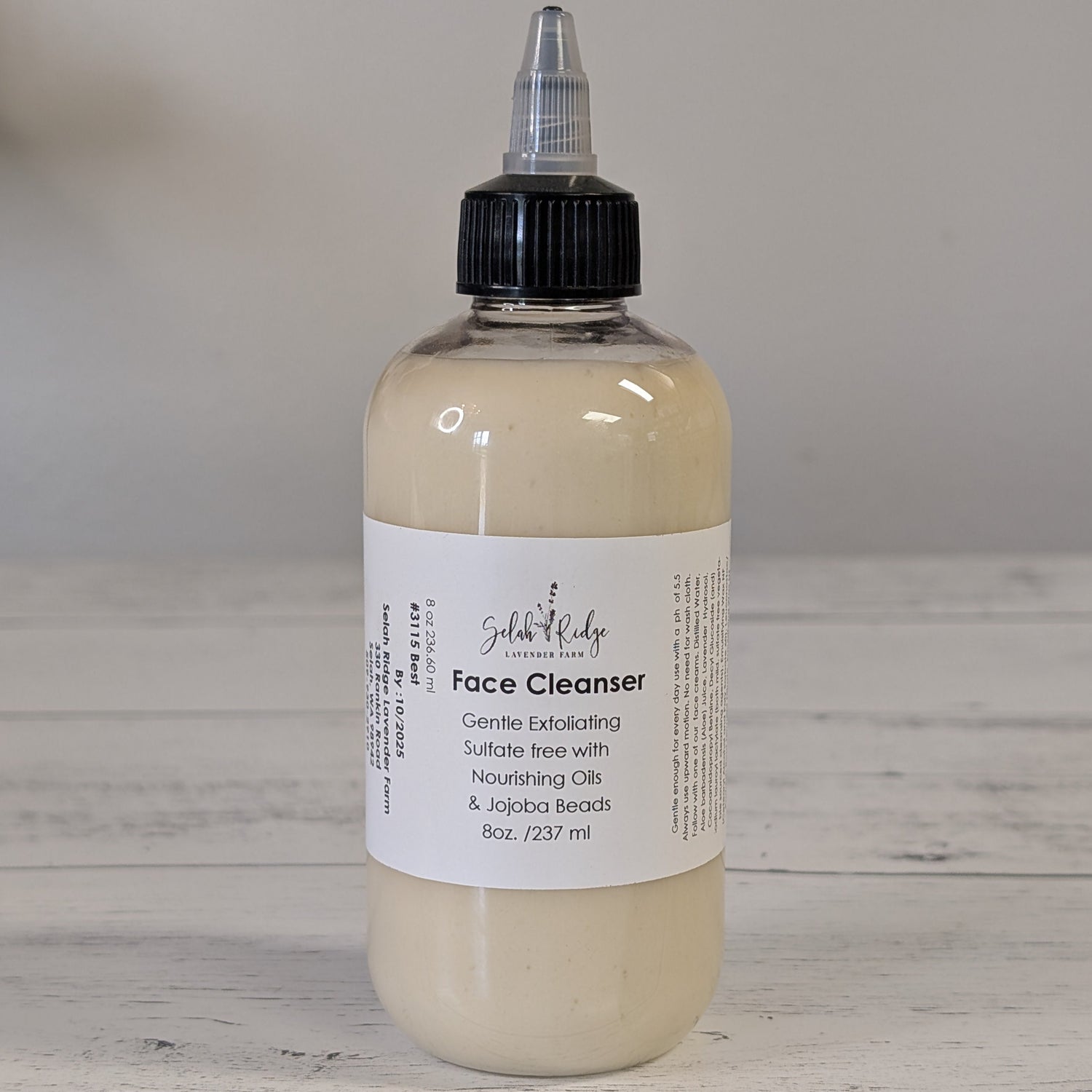 Bottle of face cleanser with a label on a wooden surface